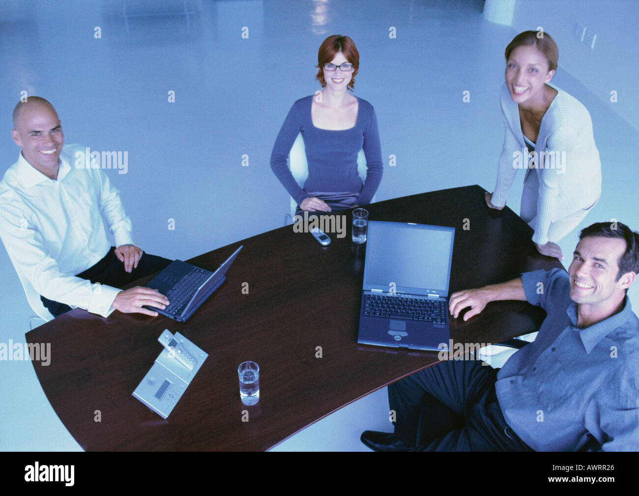 Business people around desk, smiling, elevated view Stock Photo