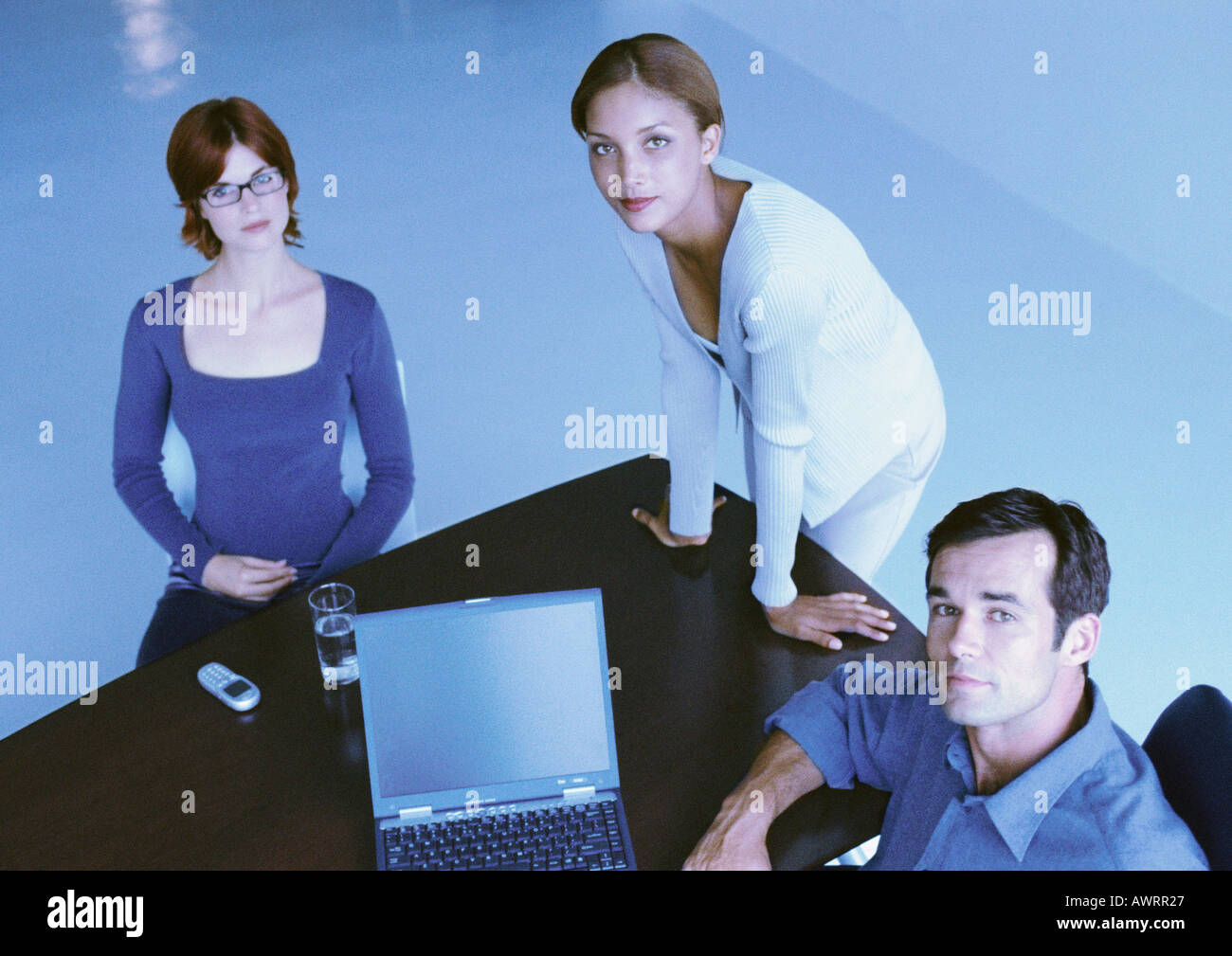 Business people around desk, smiling, elevated view Stock Photo