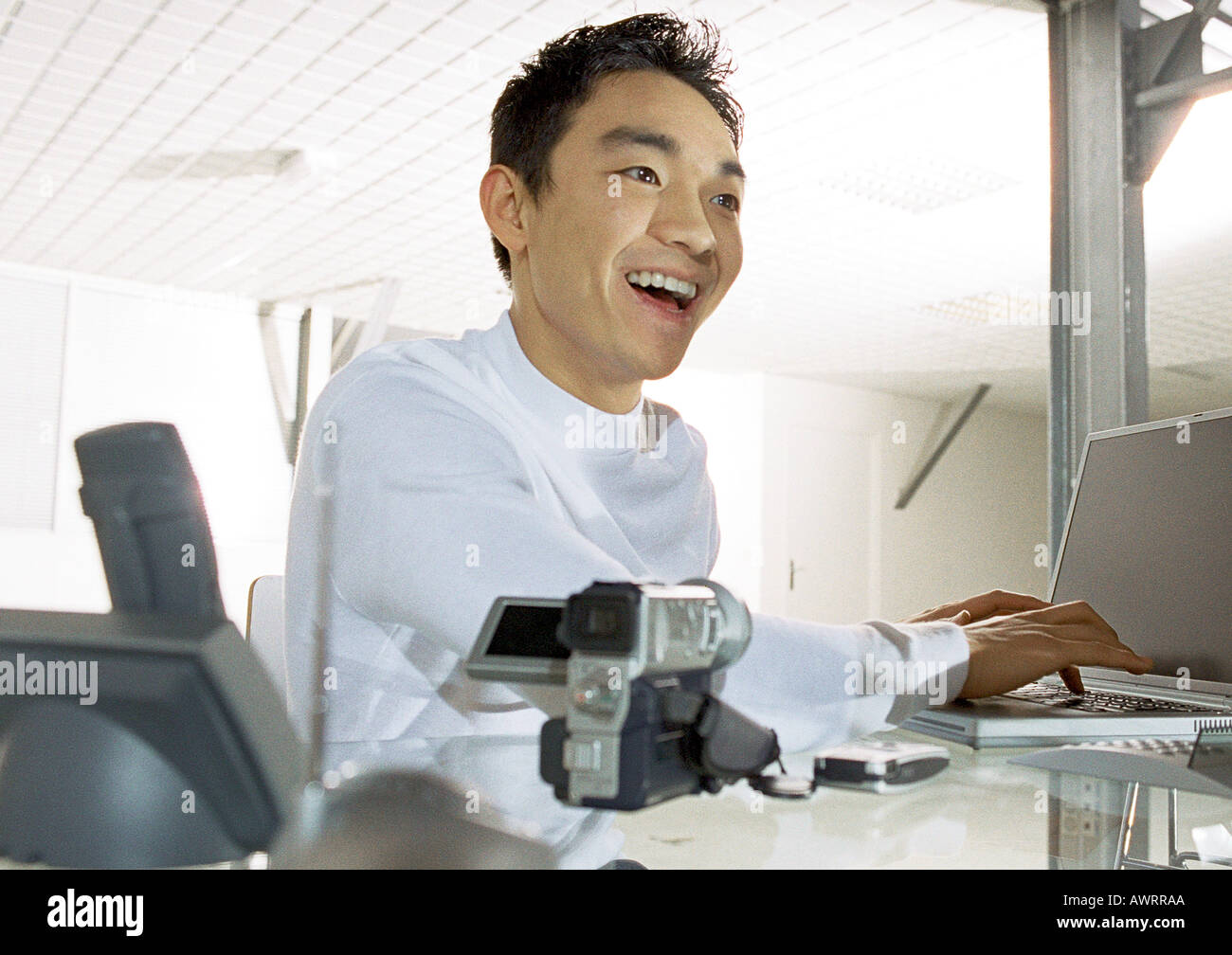 Man using laptop computer, smiling, head and shoulders Stock Photo