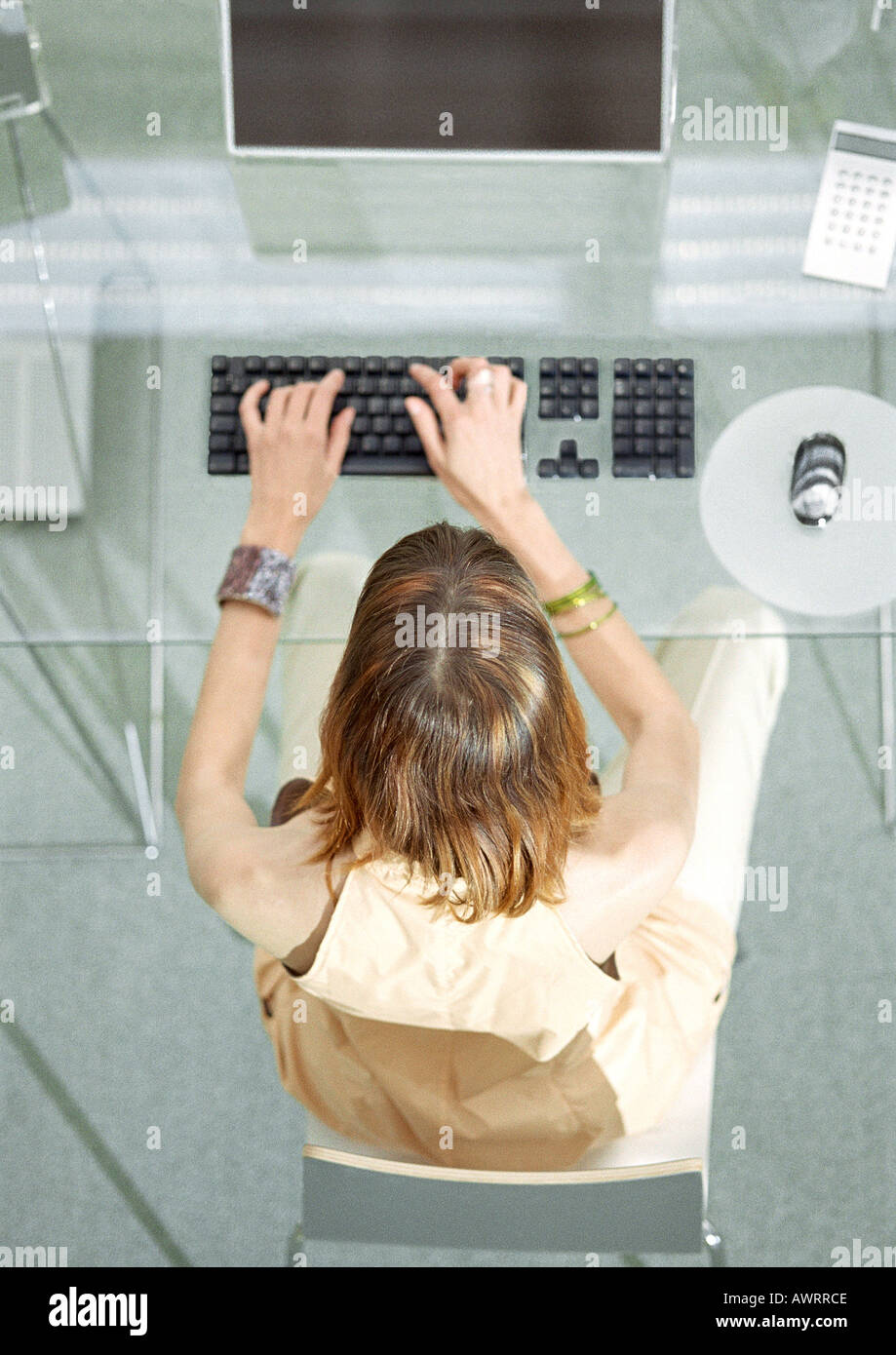 Woman at desk working on computer, elevated view Stock Photo