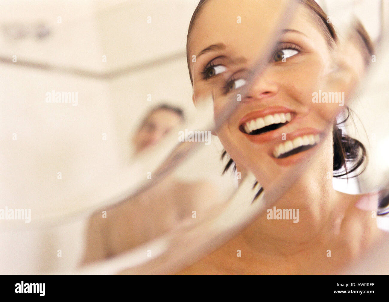 Woman looking at man in mirror, close-up, smiling, distortion Stock Photo