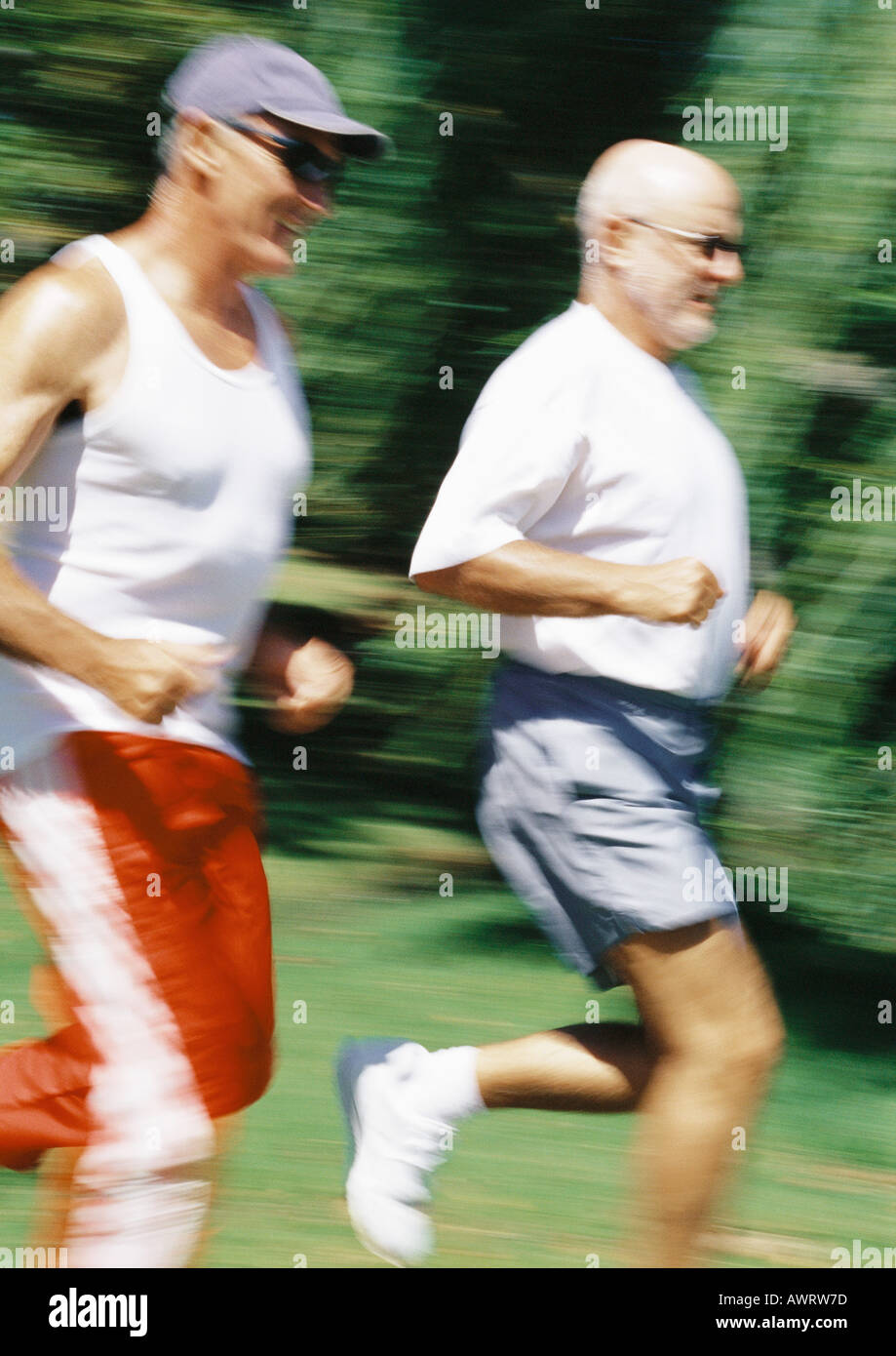 Two mature joggers in park, blurred motion Stock Photo