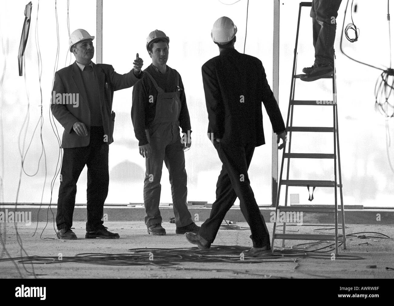 Three men wearing hard hats on building site Stock Photo Alamy