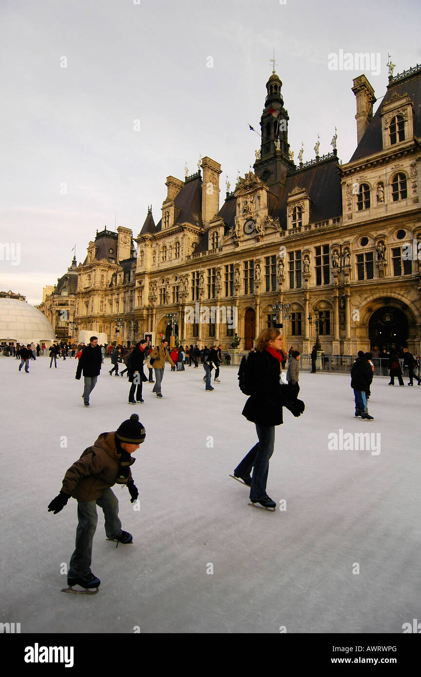 People ice skating in front of the "Hotel de Ville" (city hall), a