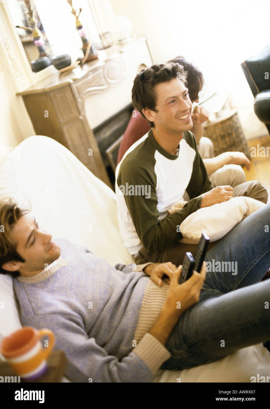 Men sitting on sofa, smiling Stock Photo