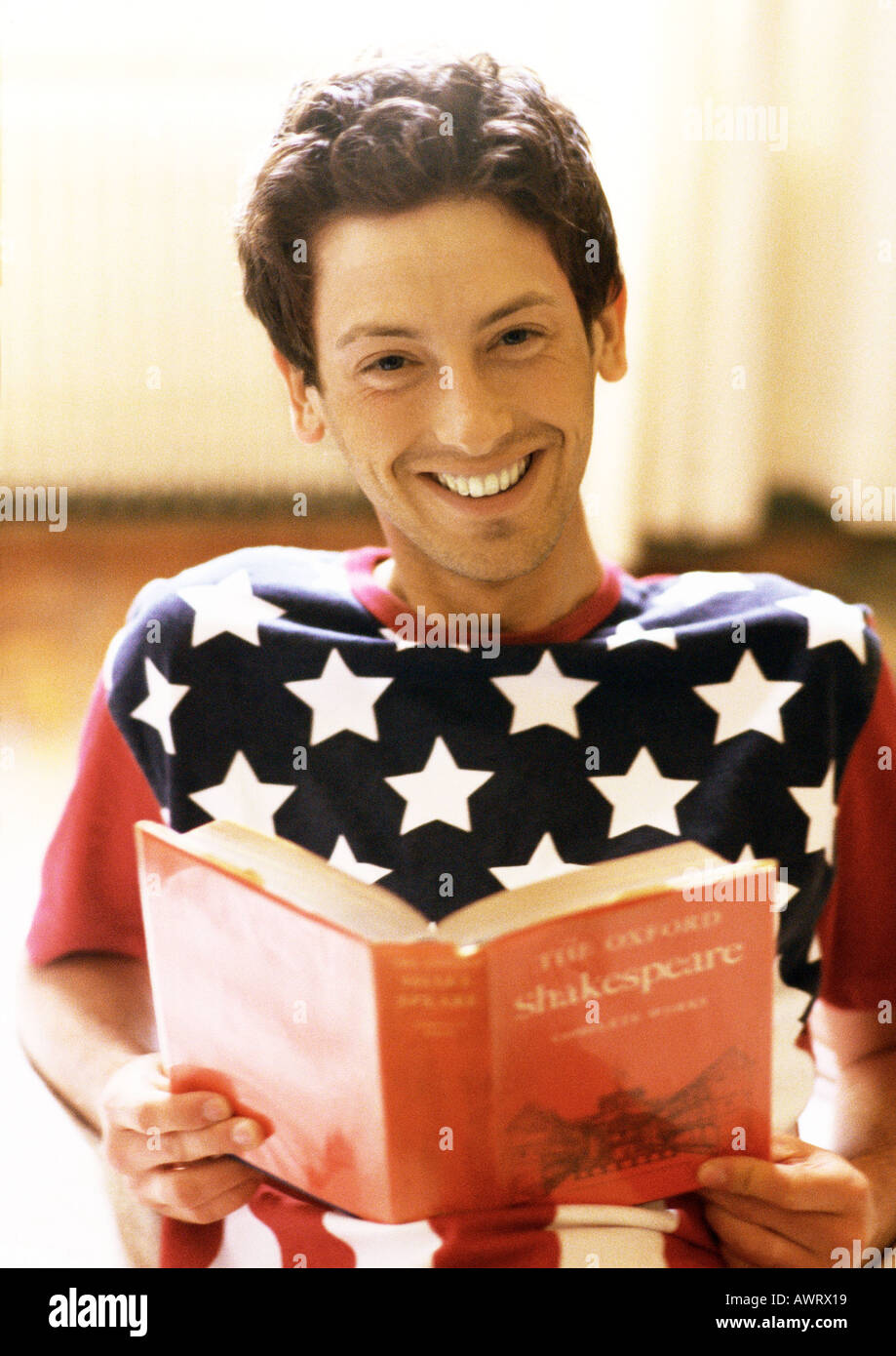 Man holding book, smiling, portrait Stock Photo
