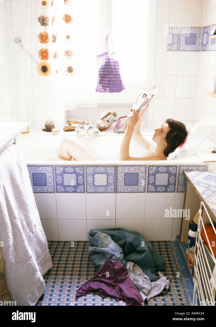 Young woman reading in bathtub Stock Photo