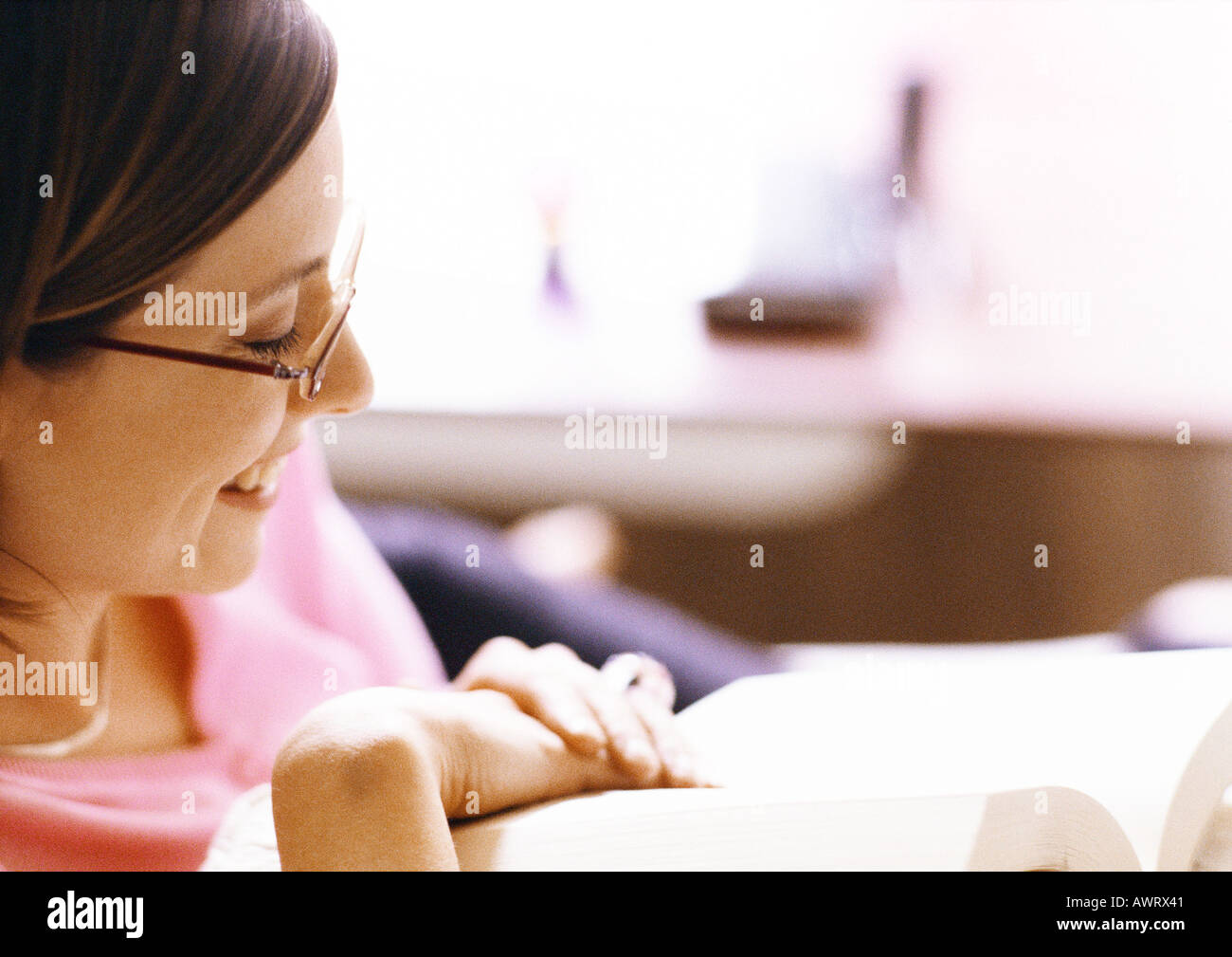 Woman reading book, smiling, close-up Stock Photo