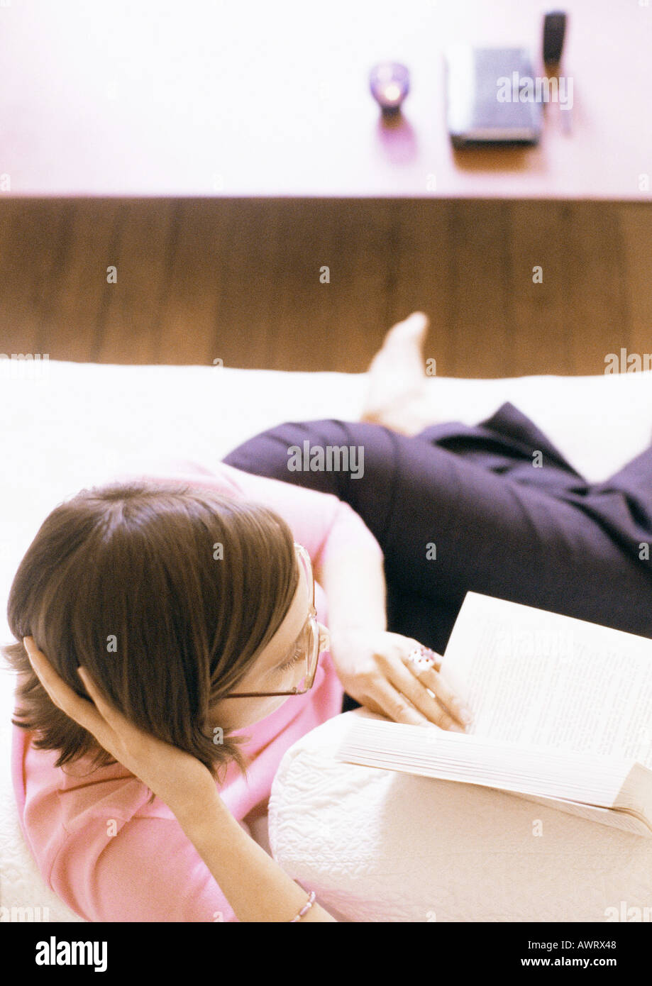 Woman lying and reading book Stock Photo