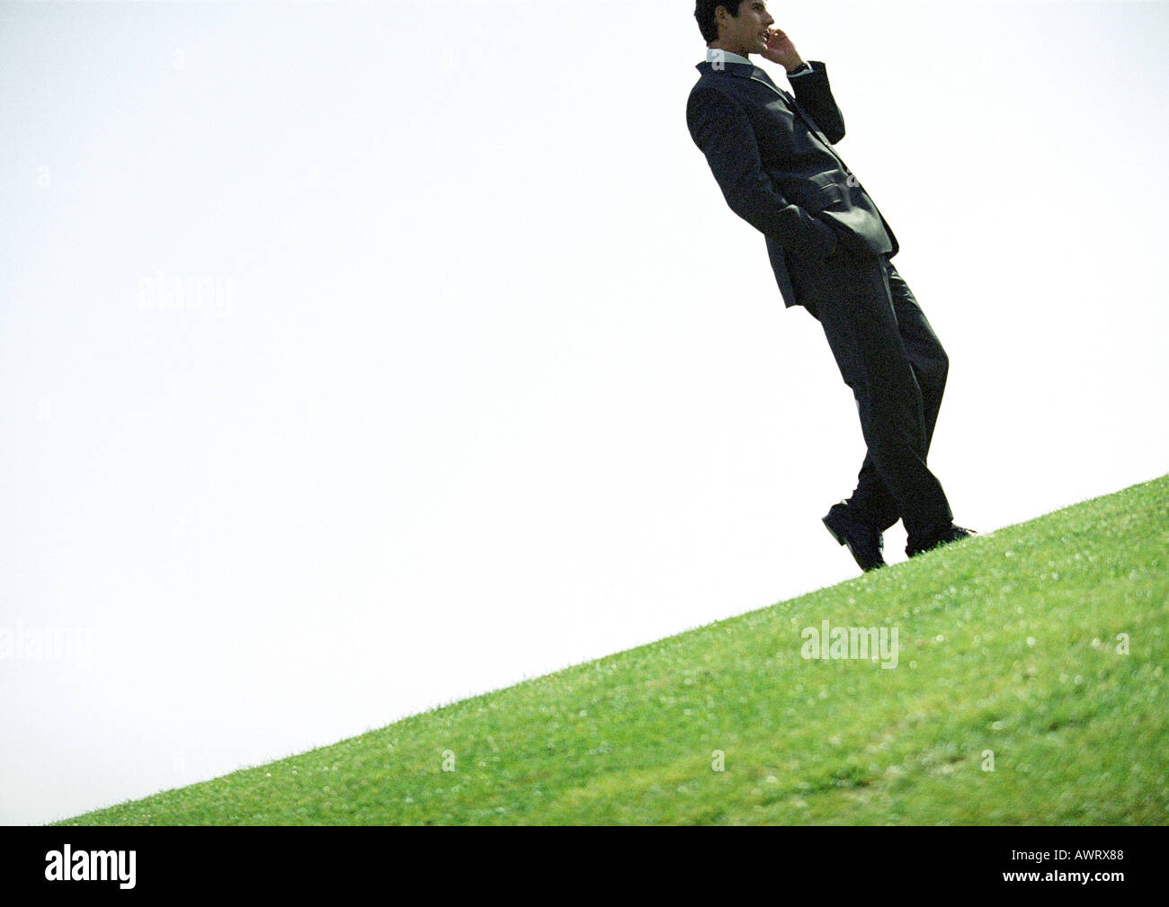 Businessman using cell phone outdoors, tilt Stock Photo