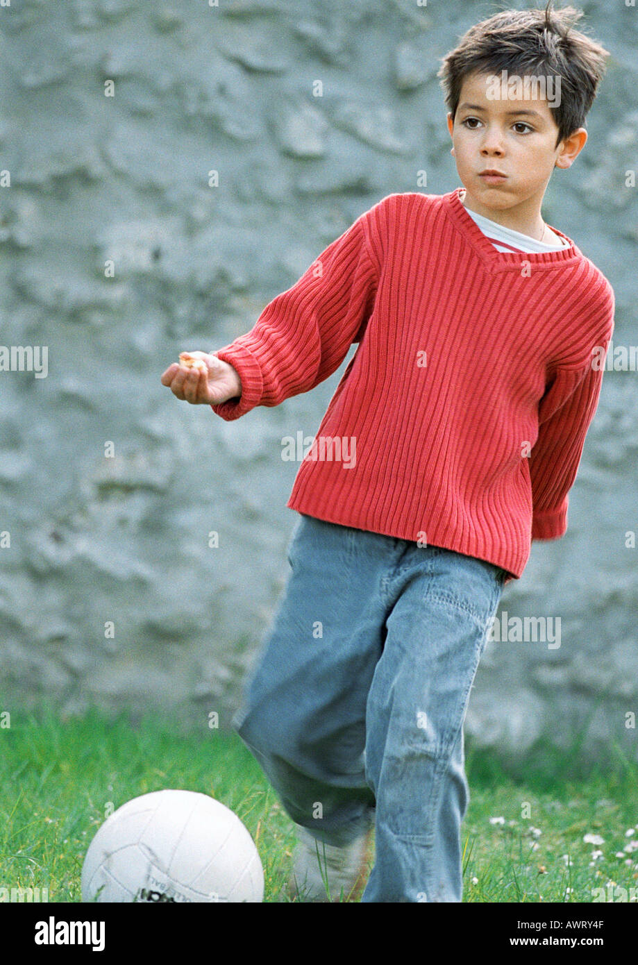 Child playing soccer, full length, close-up Stock Photo