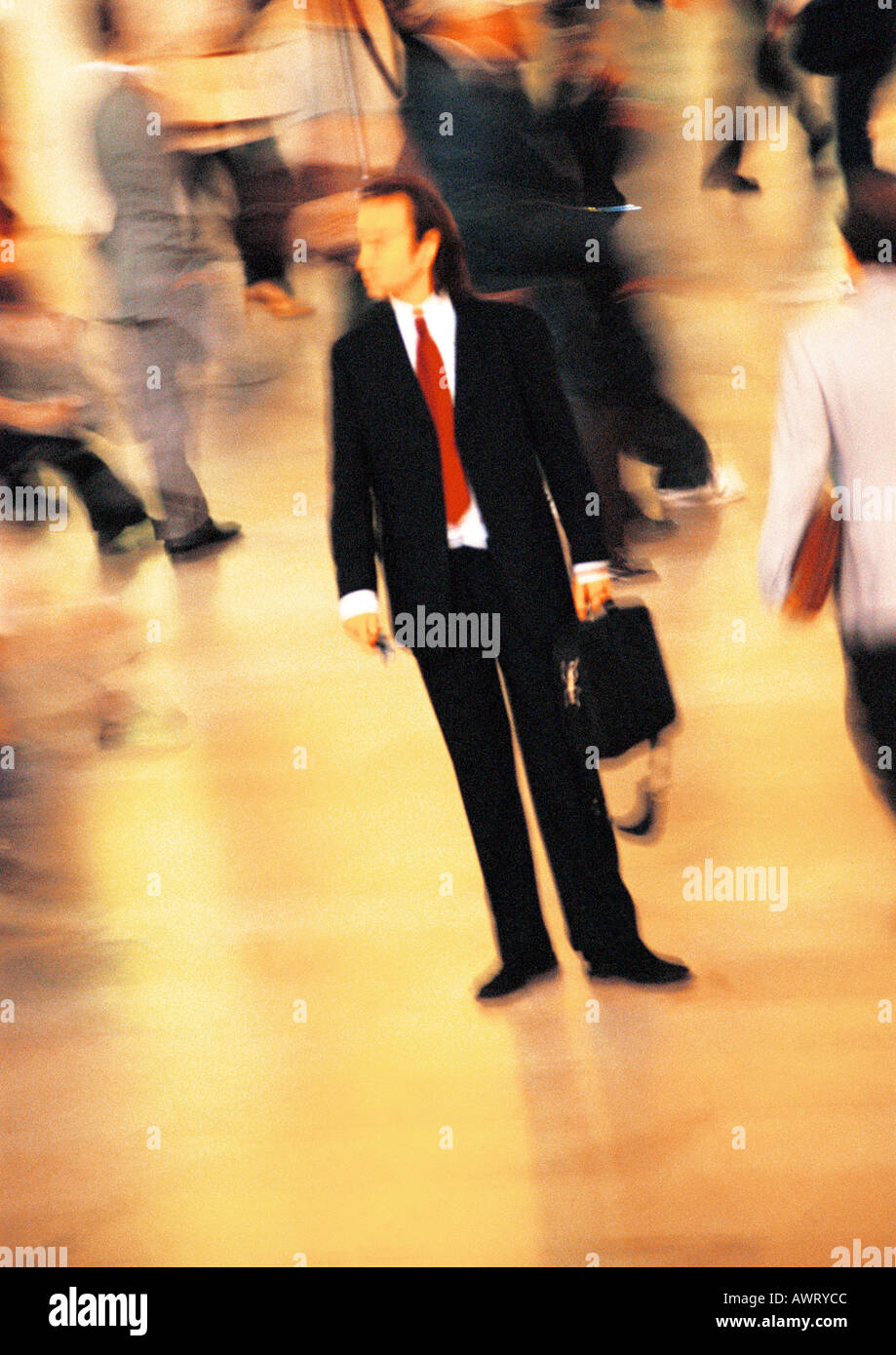 Businessman in crowd, blurred motion Stock Photo