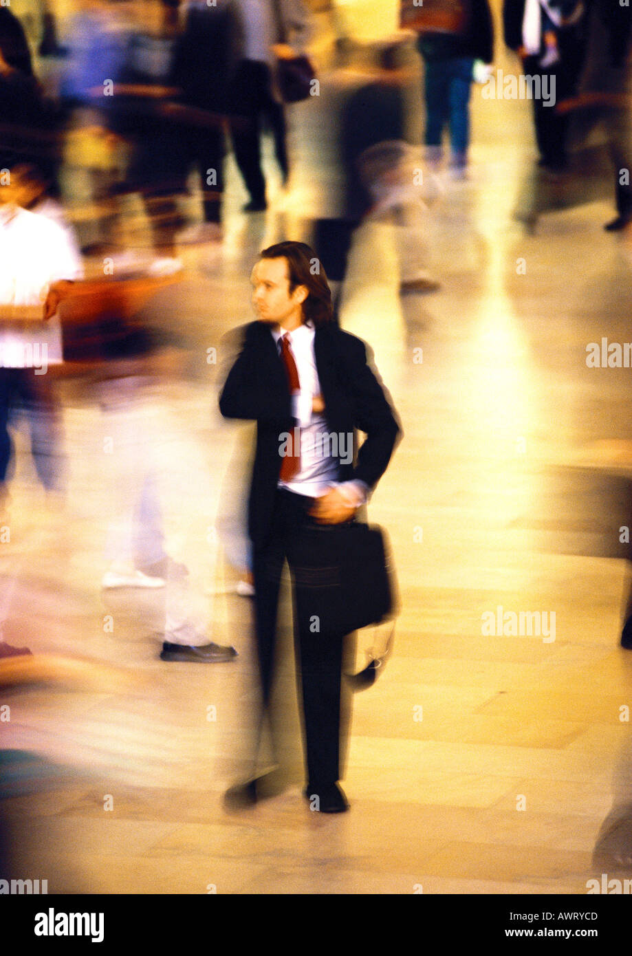 Businessman in crowd, blurred motion Stock Photo