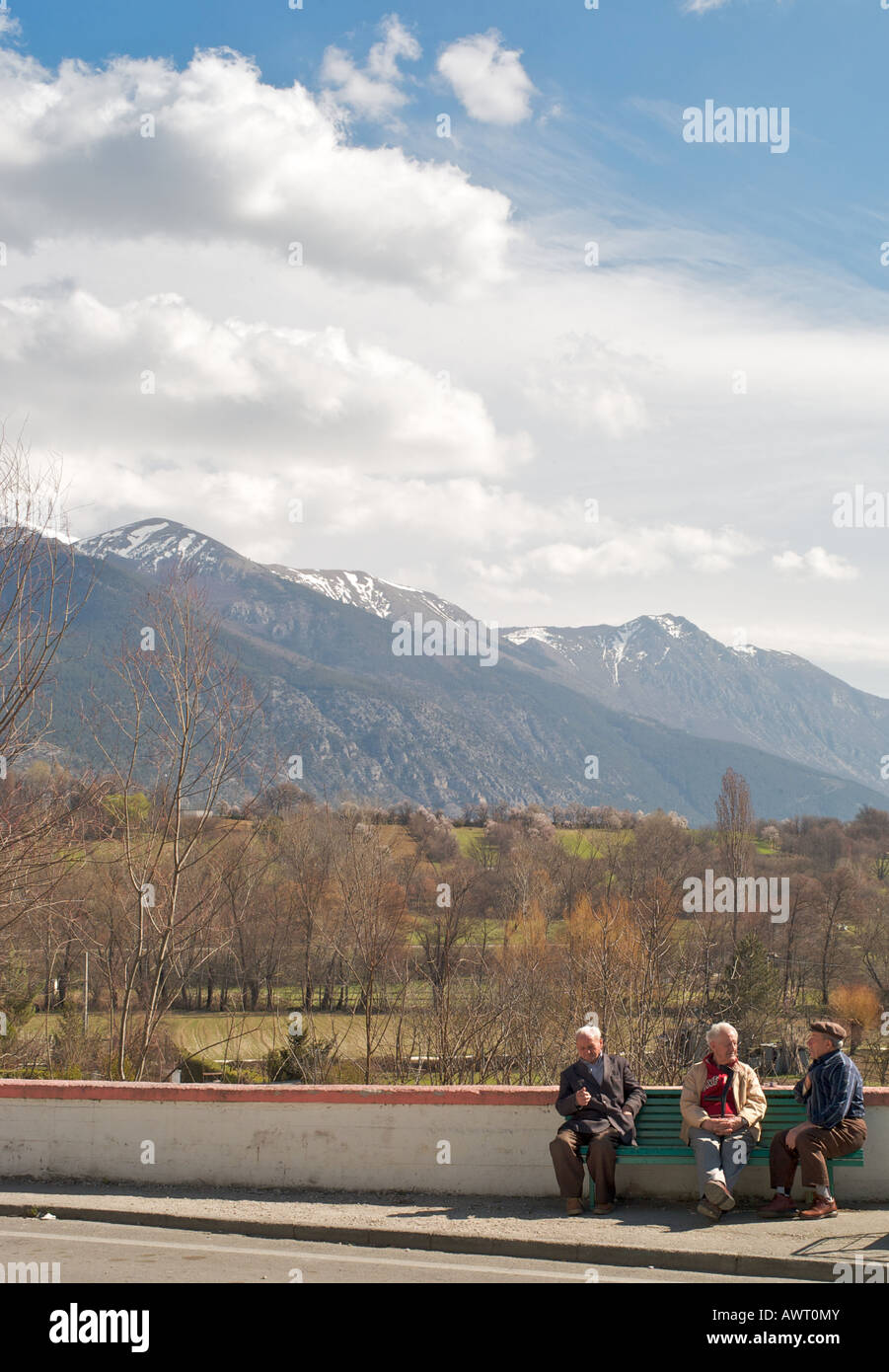 3 persons talking in Pratola in abruzzo in front of a beautiful moutain landscape Stock Photo