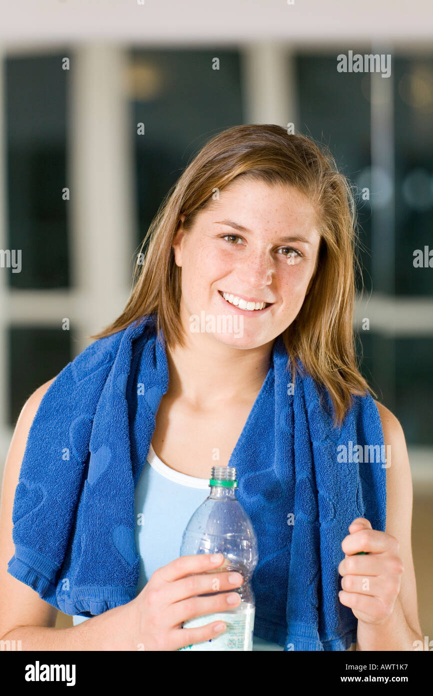 A young sportswoman with a water bottle and a towel after her workout Stock Photo