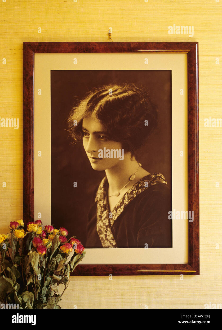 1920's vintage framed portrait of a young woman and dried roses flowers Stock Photo