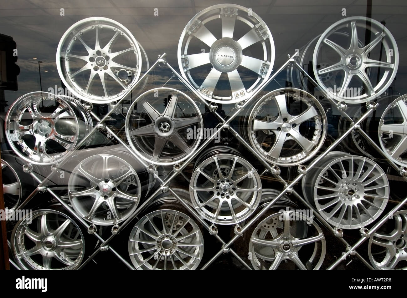 Designer alloy aluminium car wheels stacked on a metal rack in a shop