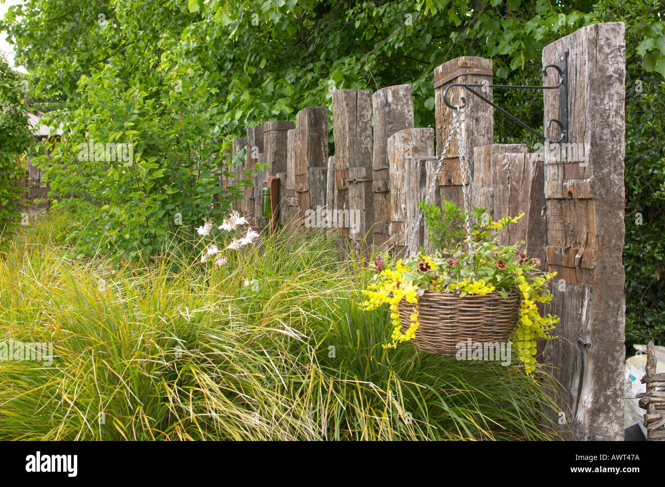 Fence made from old railway sleepers with grasses Stock Photo