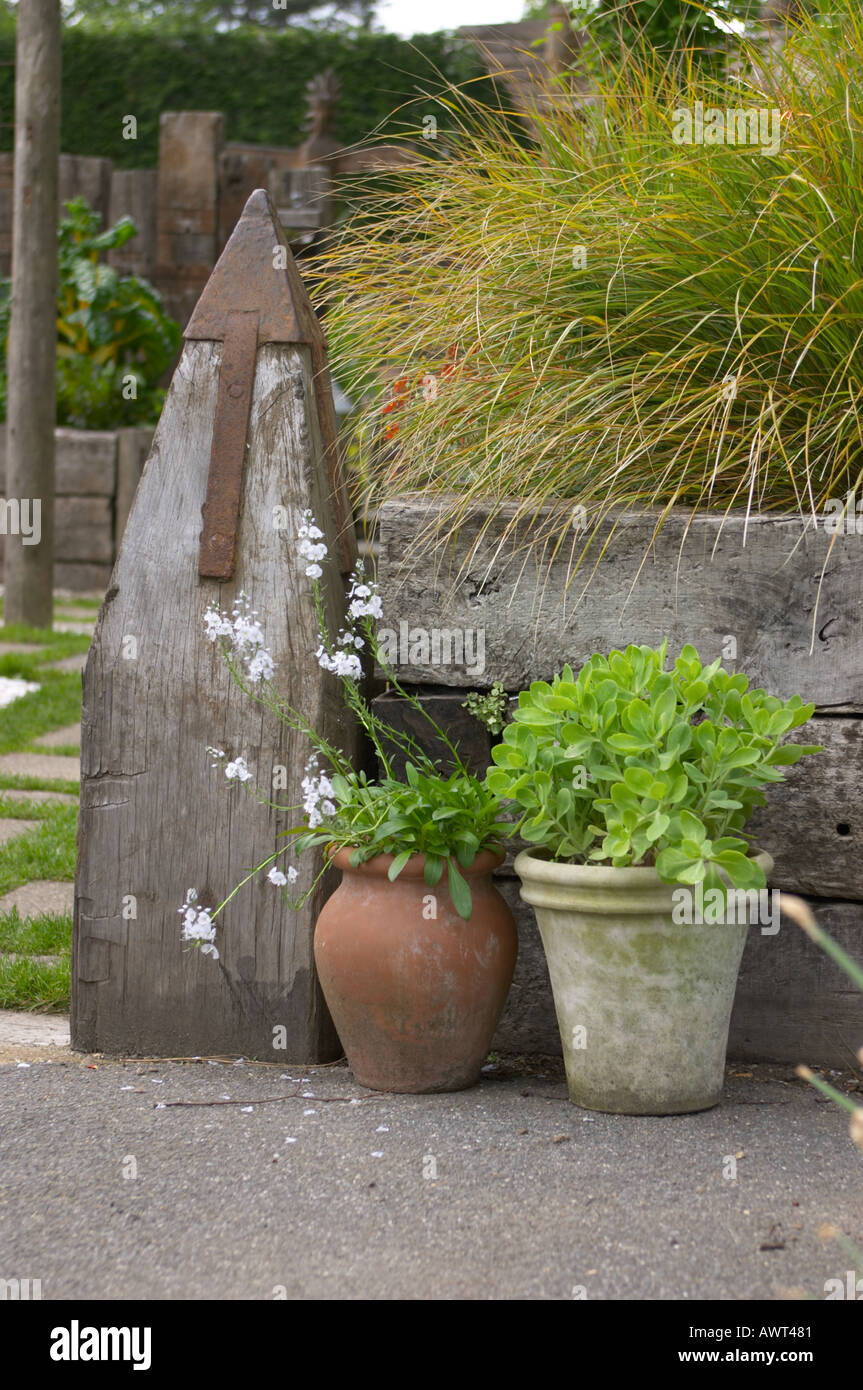 Old railway timbers used in a recycled garden With pot plants Stock Photo
