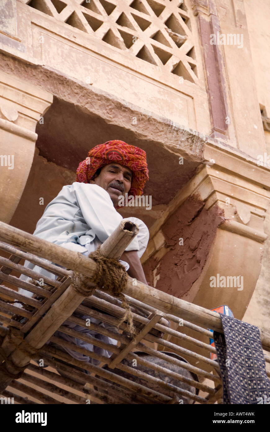 Turbaned plasterer repairs a building on scaffolding in Jaipur, India. Stock Photo