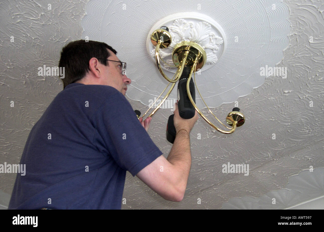 An Electrician installing a ceiling light fitting Stock Photo Alamy