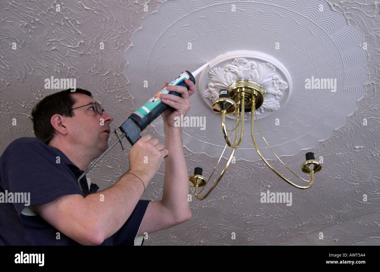 An Electrician installing a ceiling light fitting Stock Photo Alamy