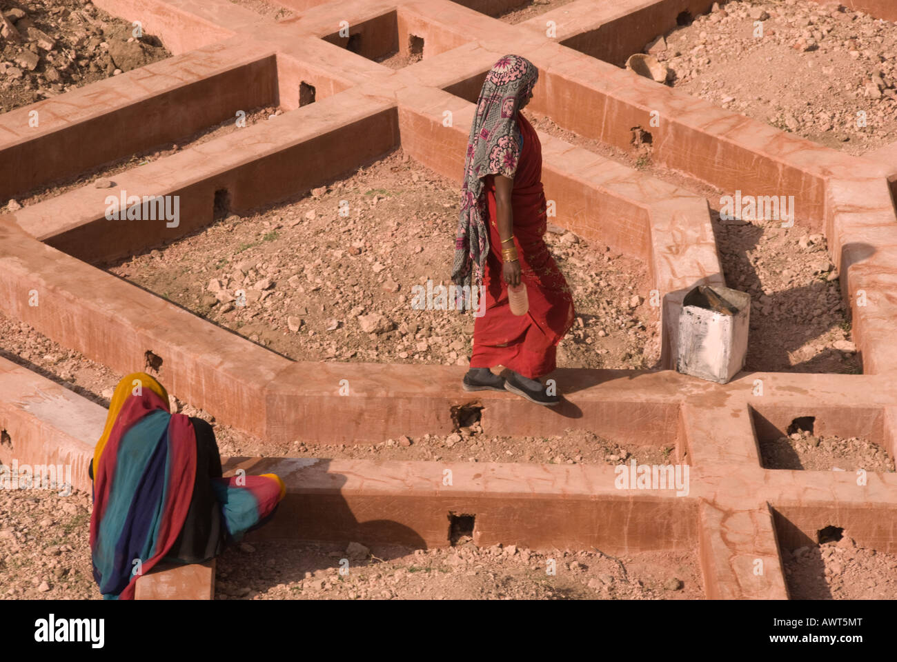 Two women working on a geometric construction project in Jaipur, India dressed in colorful saris. Stock Photo