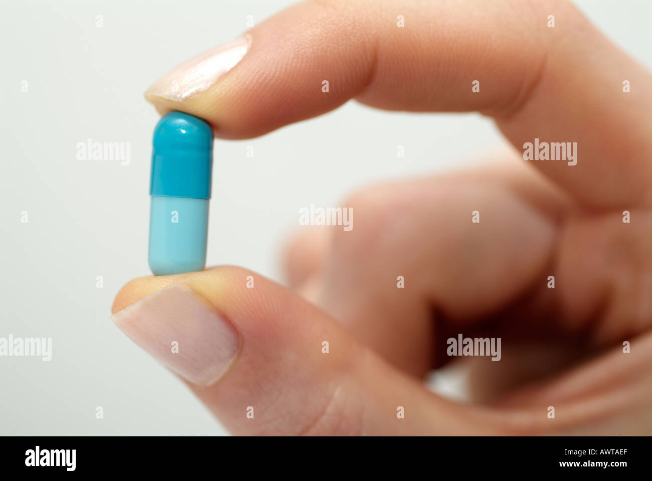 Capsule Held Between the Fingers of a Female Stock Photo