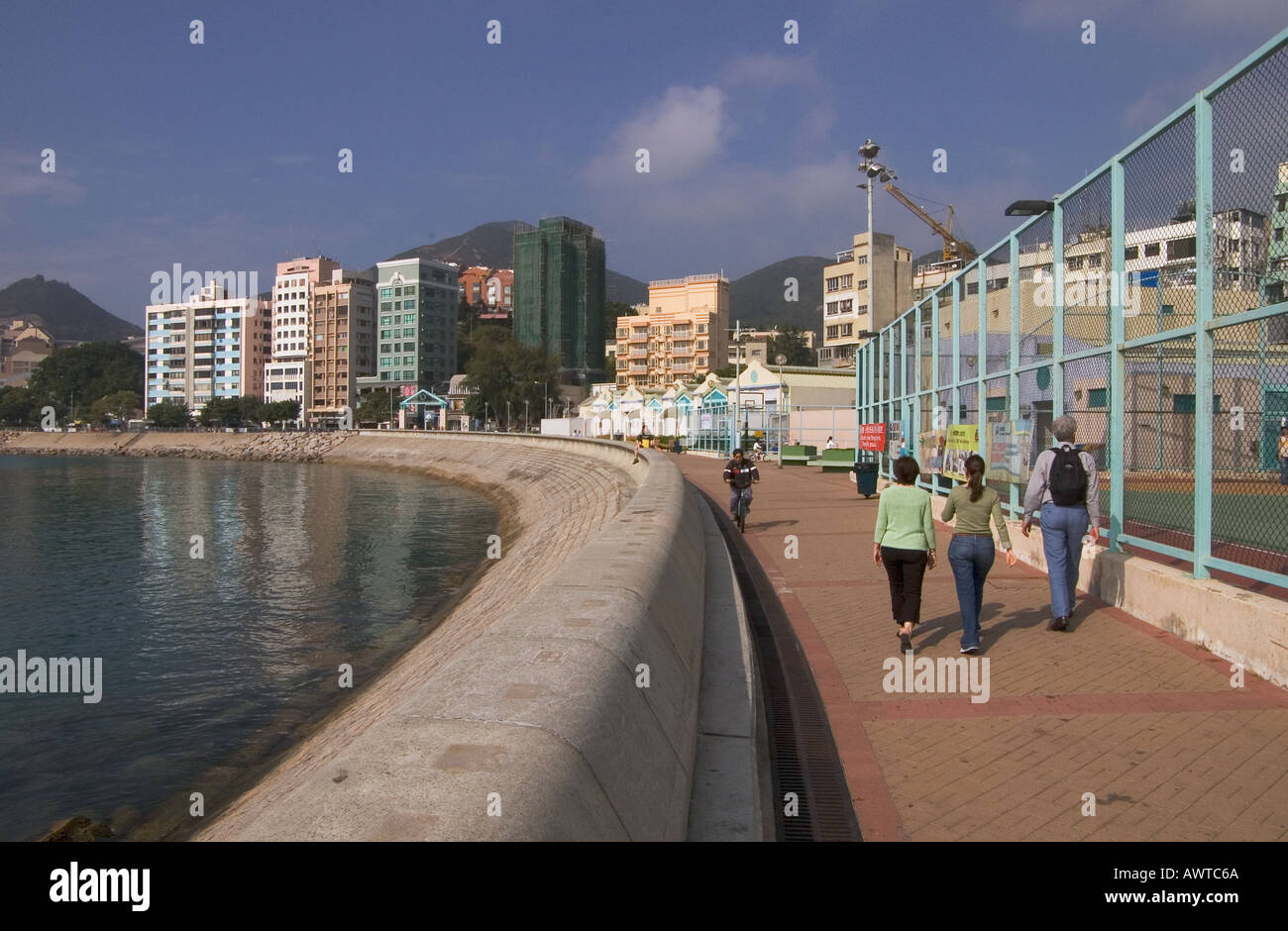 dh STANLEY HONG KONG Family walking along promenade bay and village