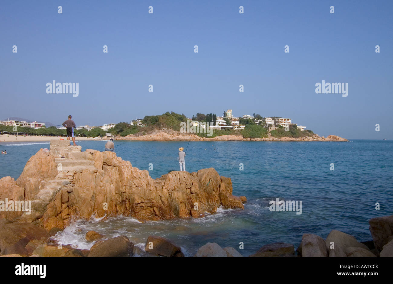 dh SHEK O HONG KONG Anglers fishing off rocks Island Bay beach angling rod village china water coast Stock Photo