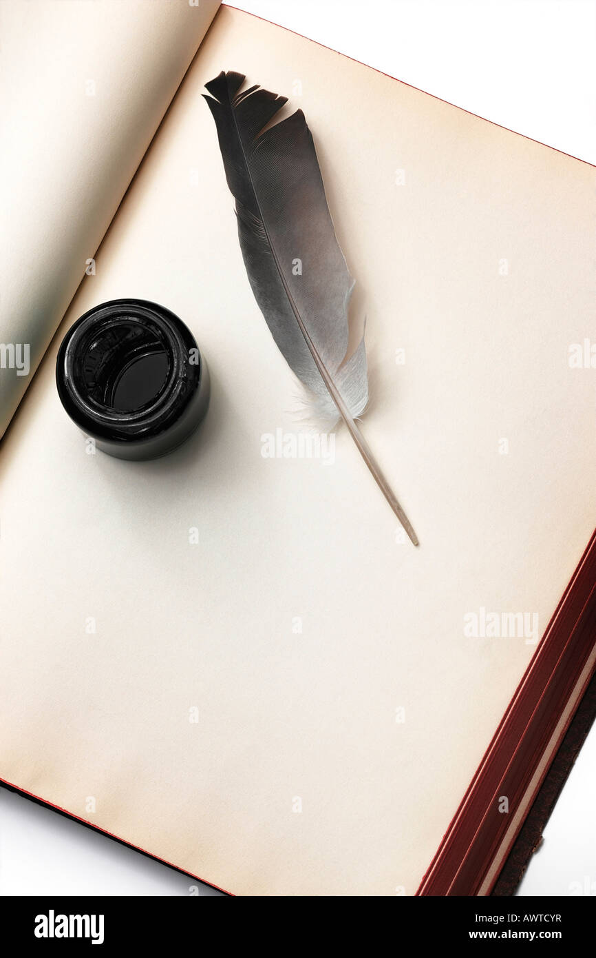 quill and an ink bottle on a blank book page Stock Photo - Alamy