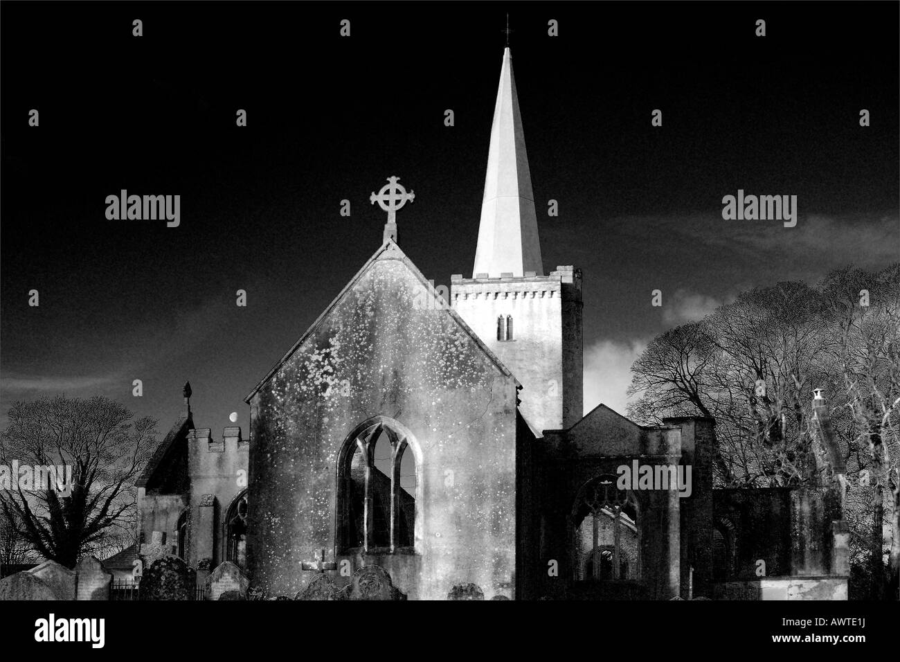Atmospheric Infrared Style monochrome image of a graveyard and derelict church with galssless windows and no roof Stock Photo