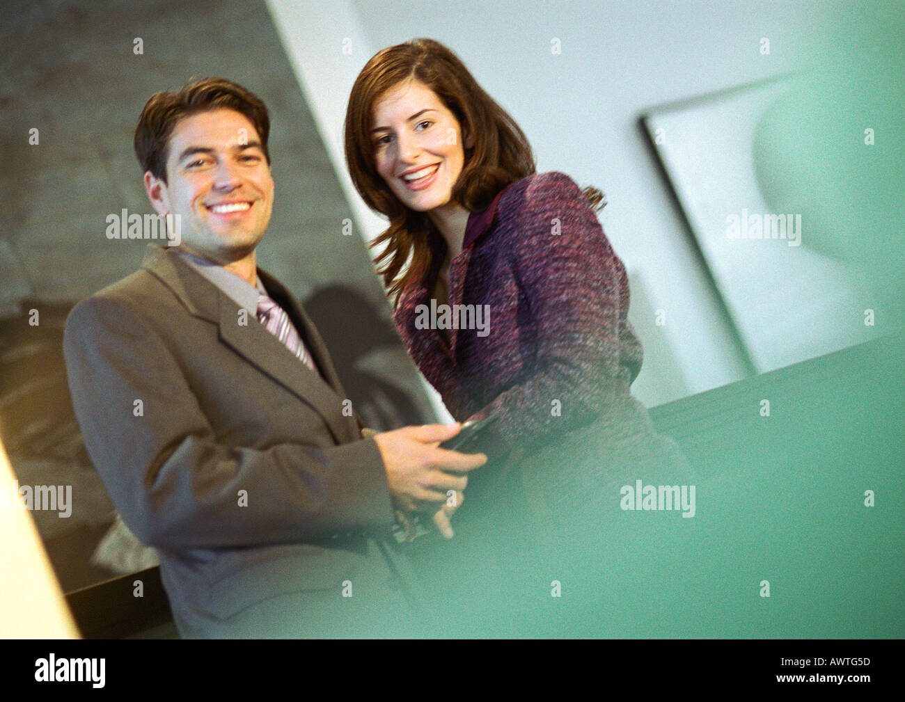 Businessman holding businesswoman's hand, smiling at camera Stock Photo