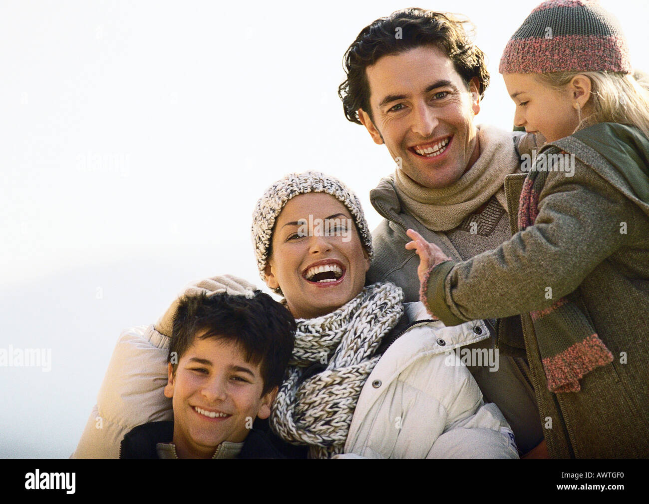 Adult man and woman with two children, smiling, warmly dressed ...