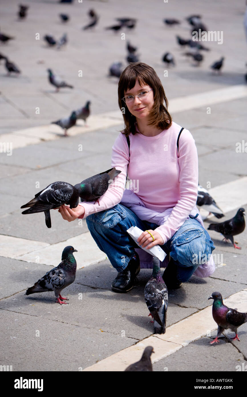 Young girl feeding pigeons in St Mark's Square, Venice, Italy Stock Photo Alamy