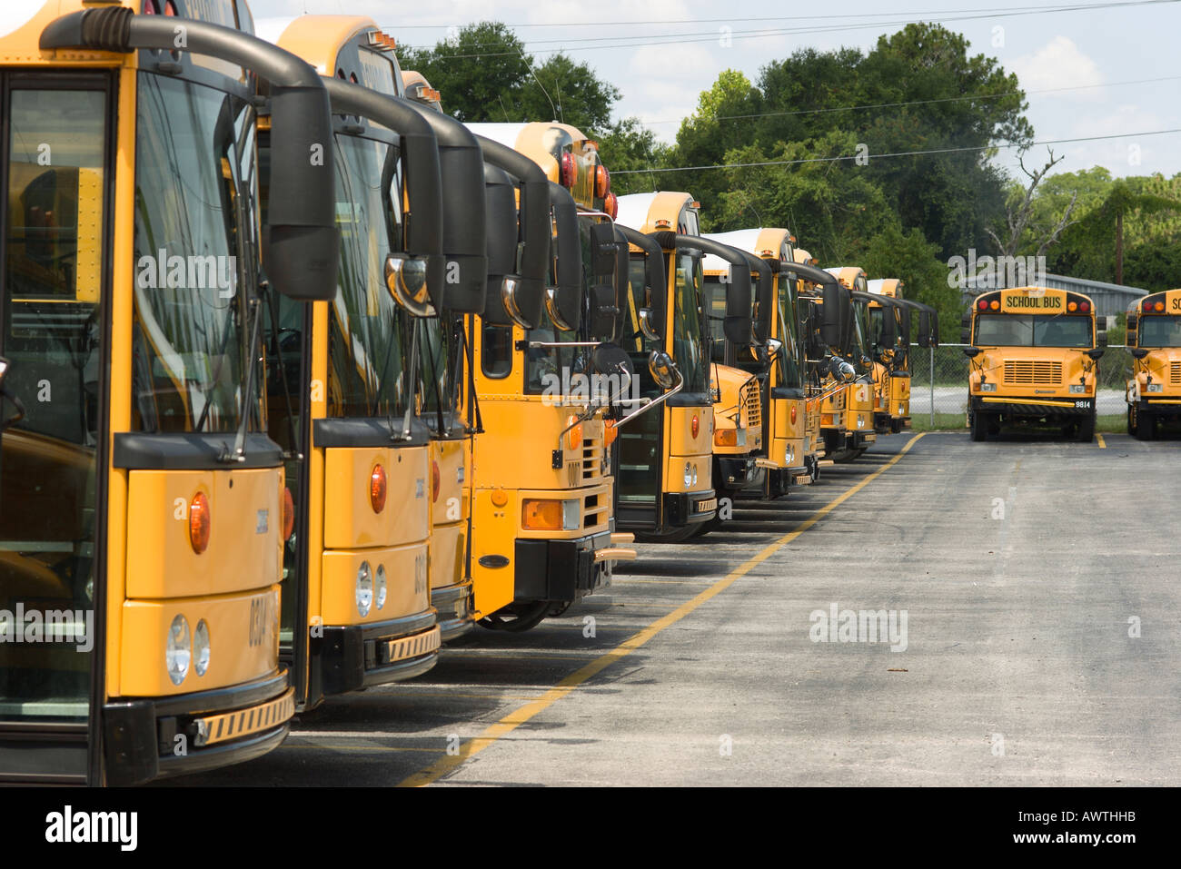 A variety of different types of school buses fill the lot waiting to be