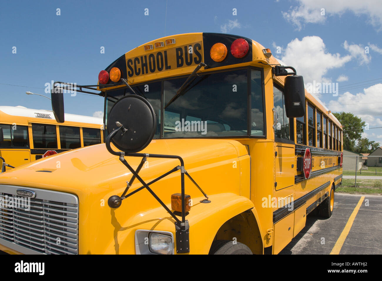 A variety of different types of school buses fill the lot waiting to be