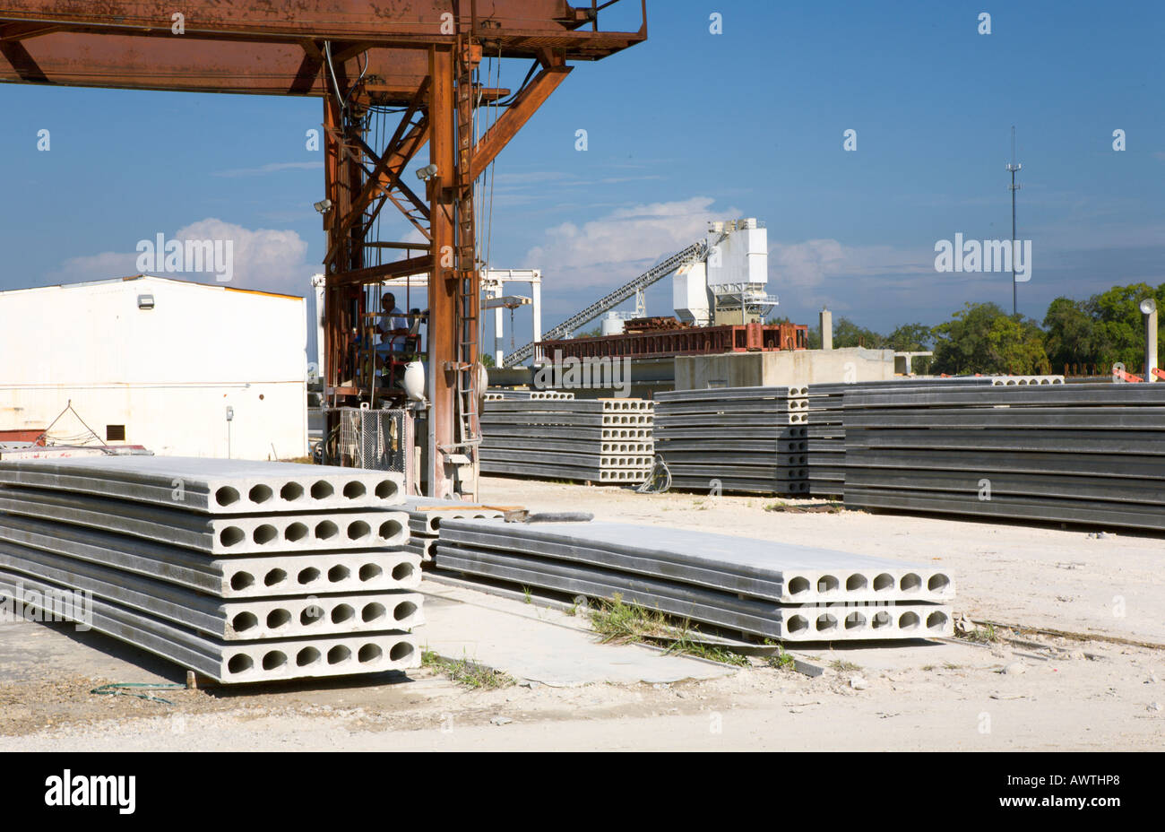 Concrete batch plant behind precast concrete products and forms at manufacturing yard in Florida, USA Stock Photo