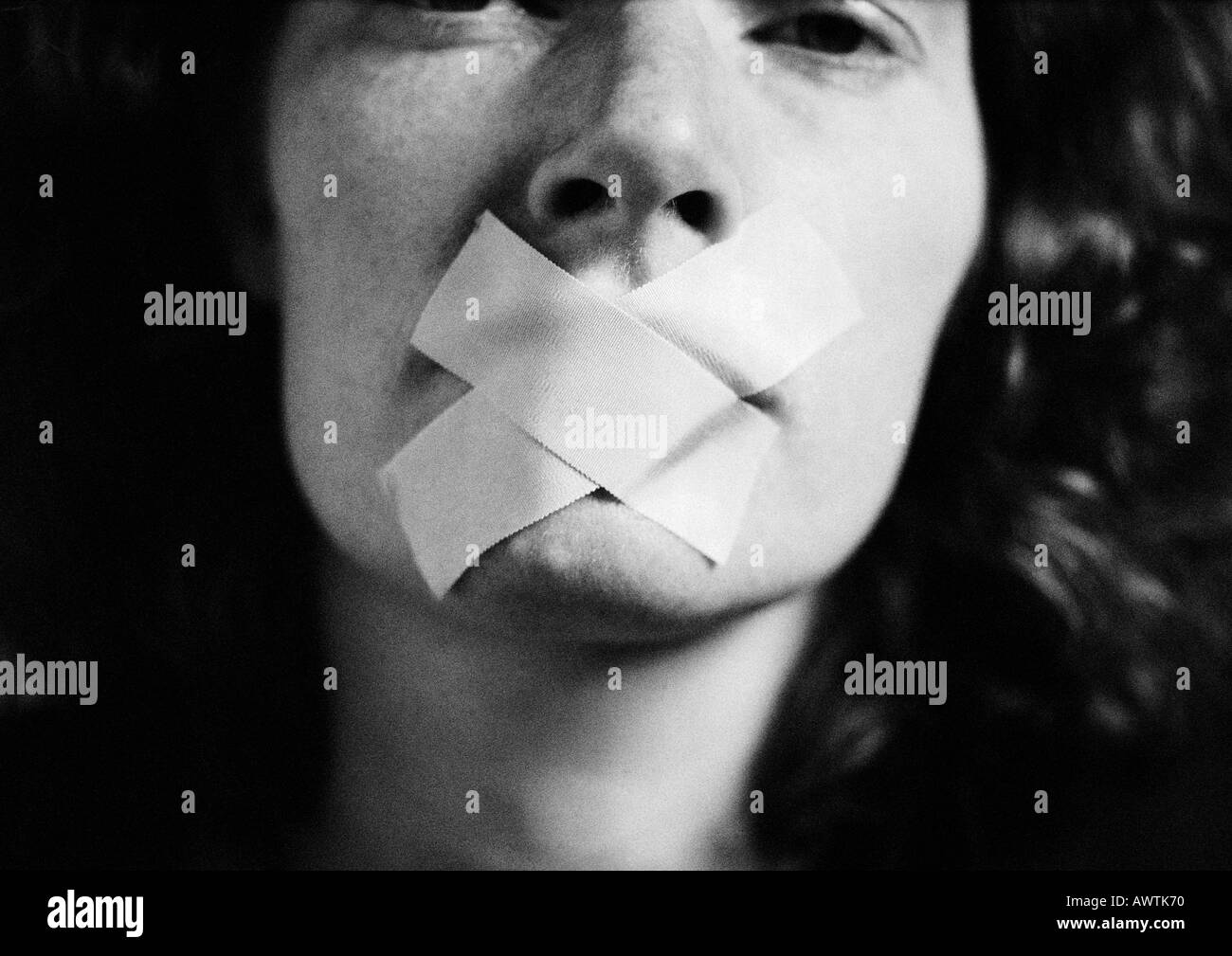 Woman with tape over mouth, close-up, blurred Stock Photo