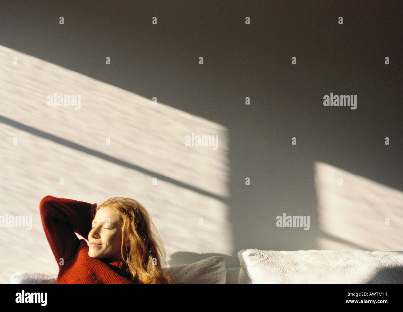 Woman sitting on couch, eyes closed Stock Photo - Alamy