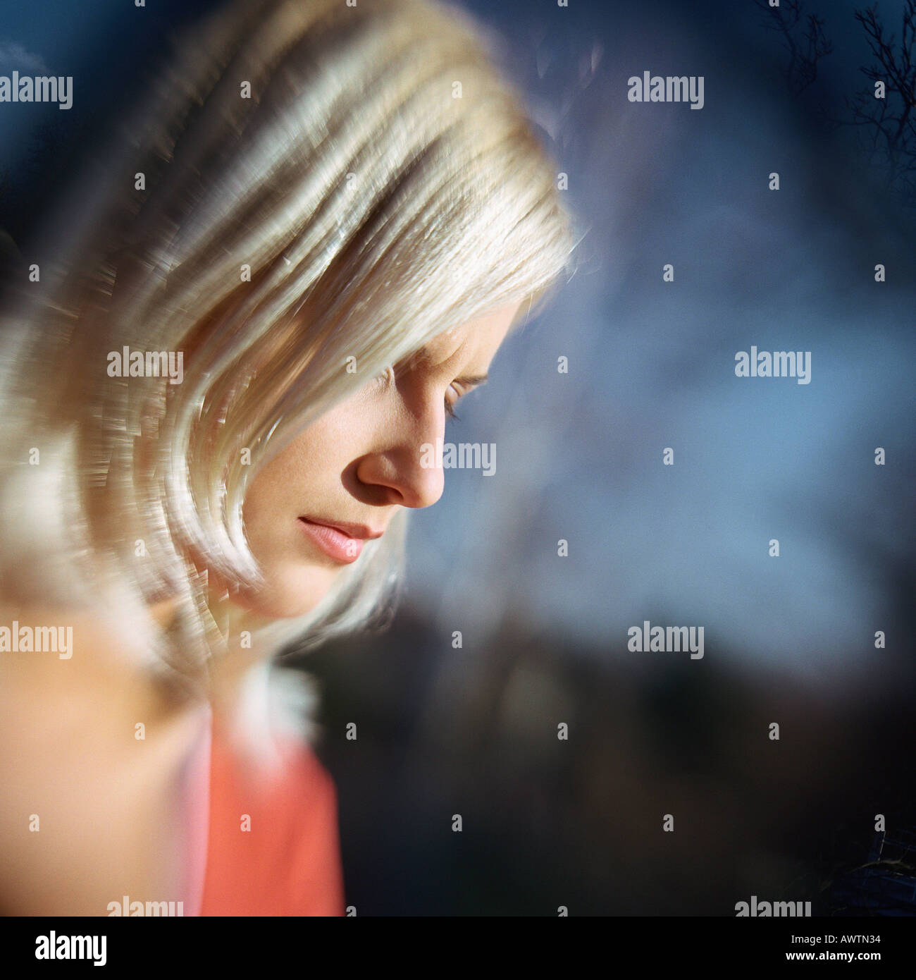 Woman looking down, side view, portrait Stock Photo