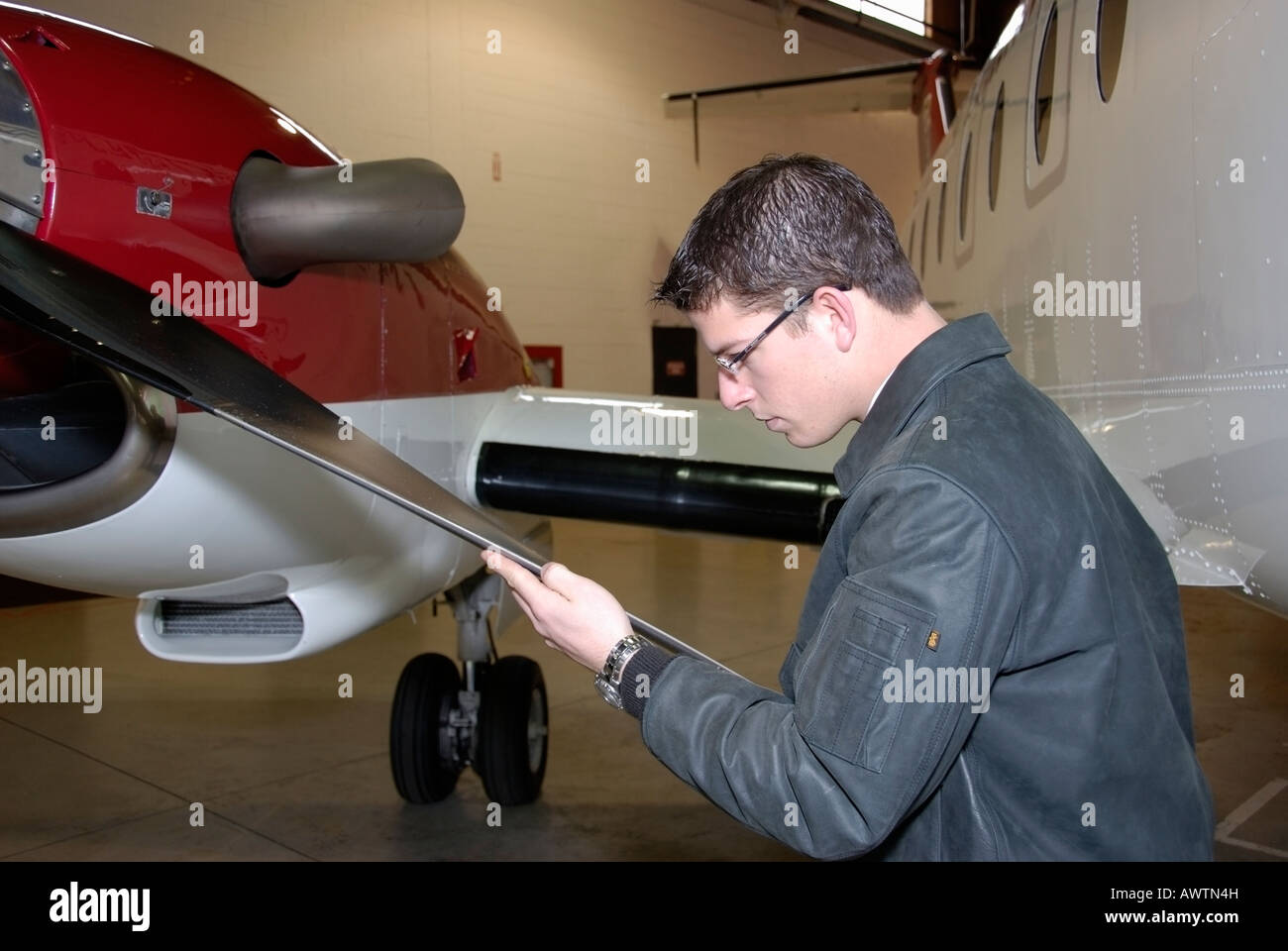 A pilot does a preflight check of the propeller blades for damage Stock