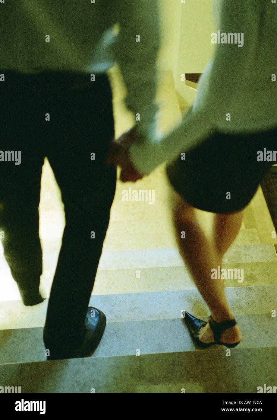 Couple walking down stairs, holding hands, rear view Stock Photo Alamy