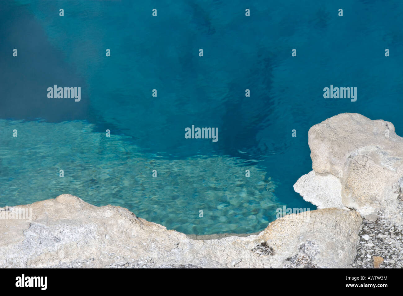 Crystal clear blue water shows formations and depth at Sapphire Pool, Yellowstone National Park, Wyoming Stock Photo