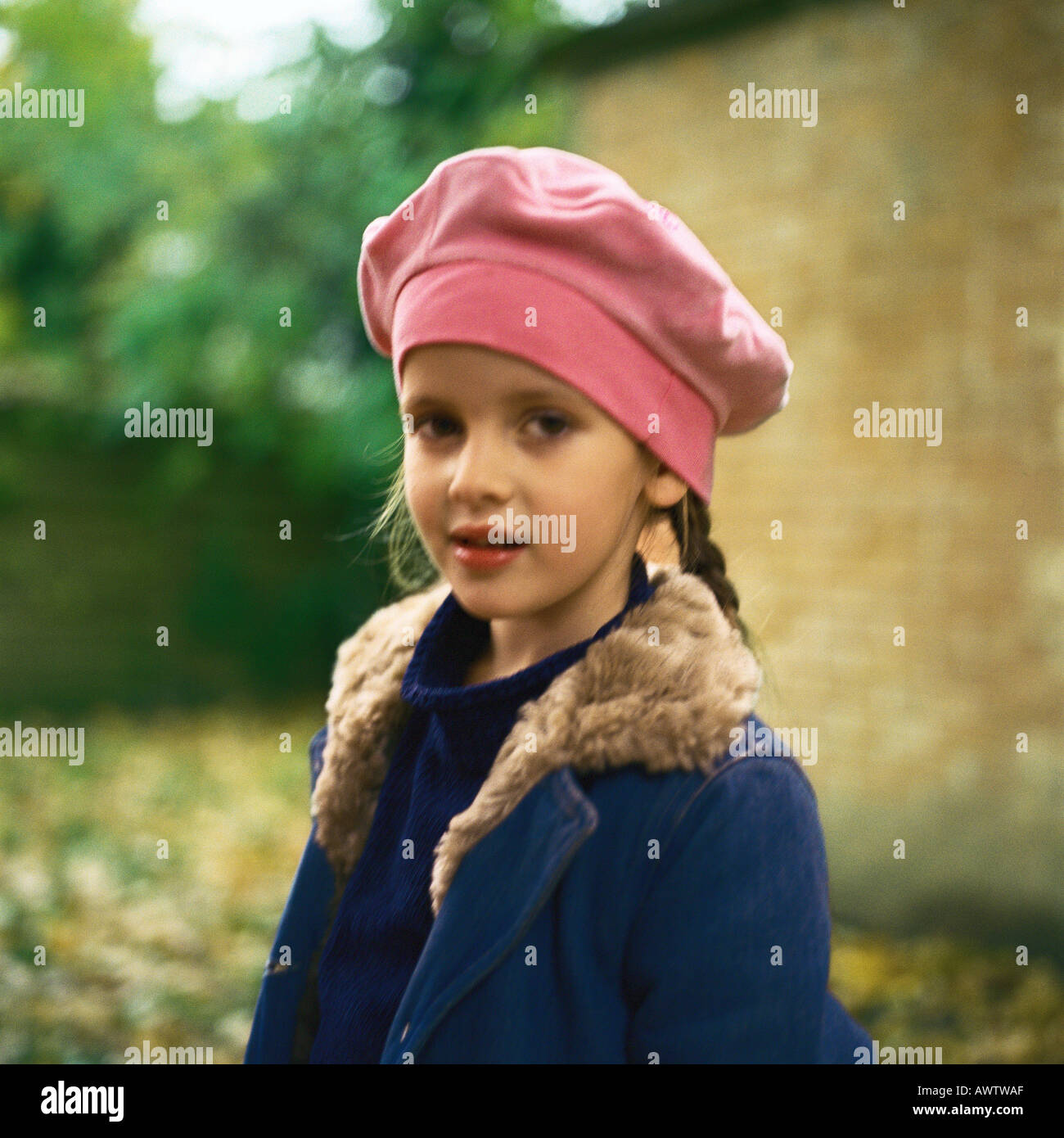 Girl outside wearing pink beret, winter coat, looking at camera Stock