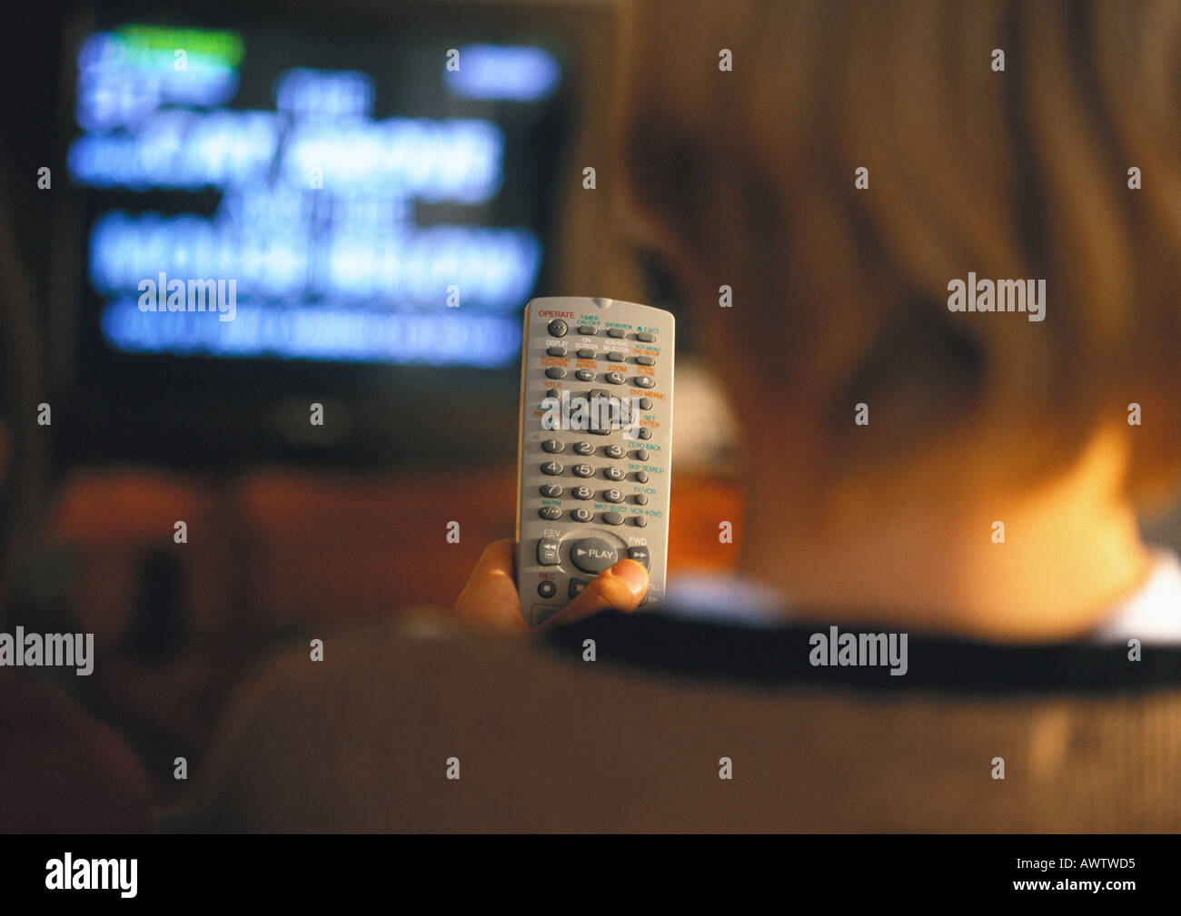 Young boy with remote in hand watching TV, rear view, close up Stock Photo