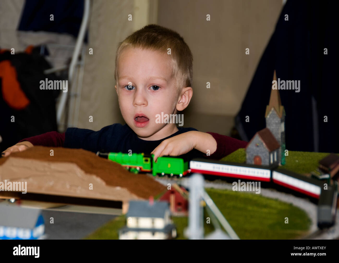 A three year old boy and electric train. Stock Photo