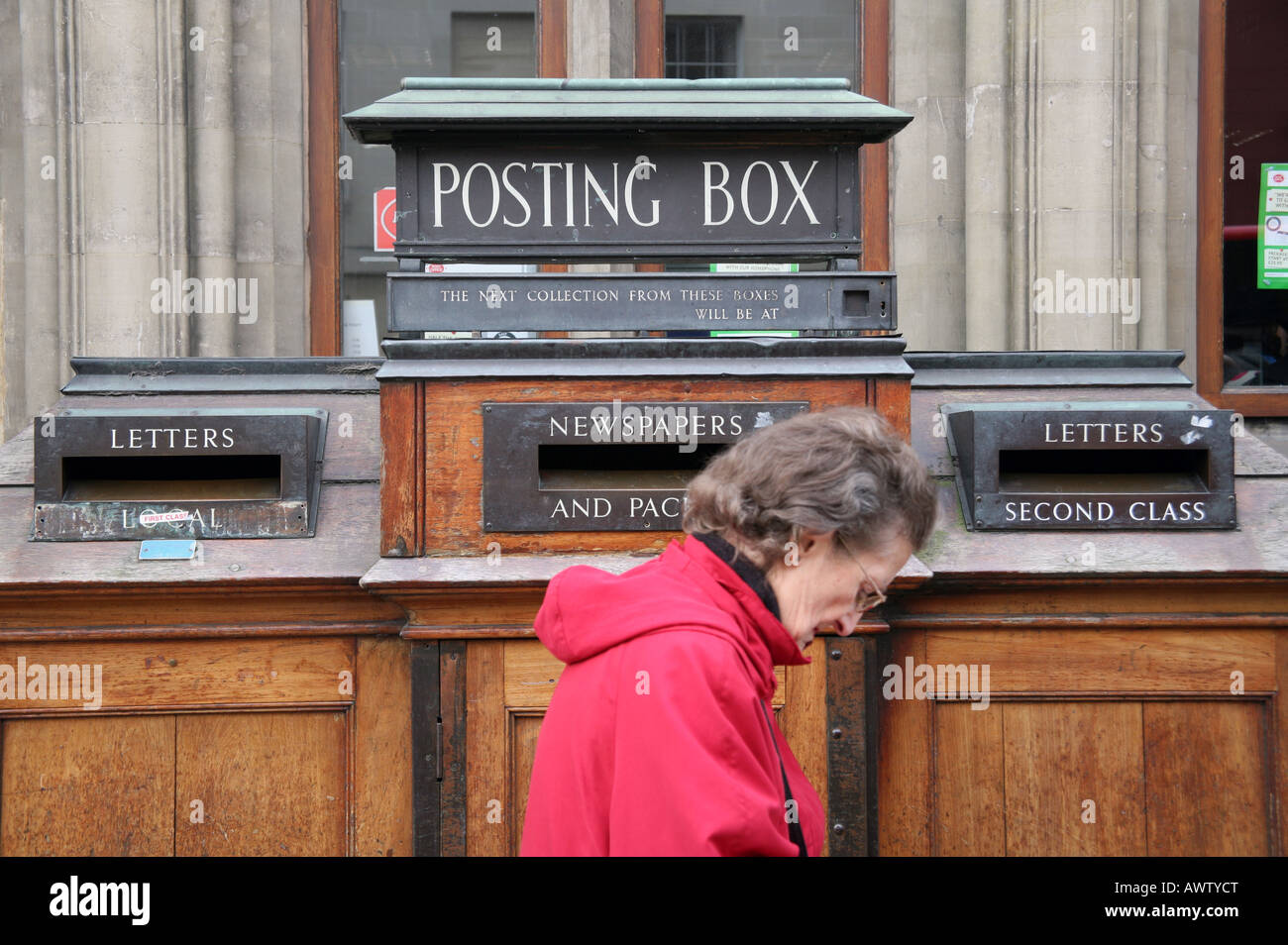 Woman in front of Post Office posting box Stock Photo Alamy
