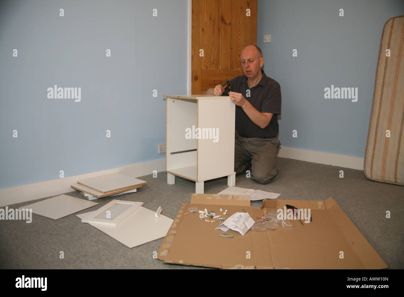 Man putting furniture together bought from Ikea Stock Photo Alamy