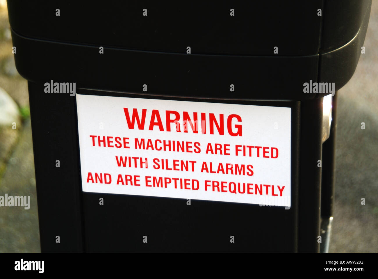 On street car parking ticket machine warning notice of silent alarm and frequent emptying of coins Stock Photo